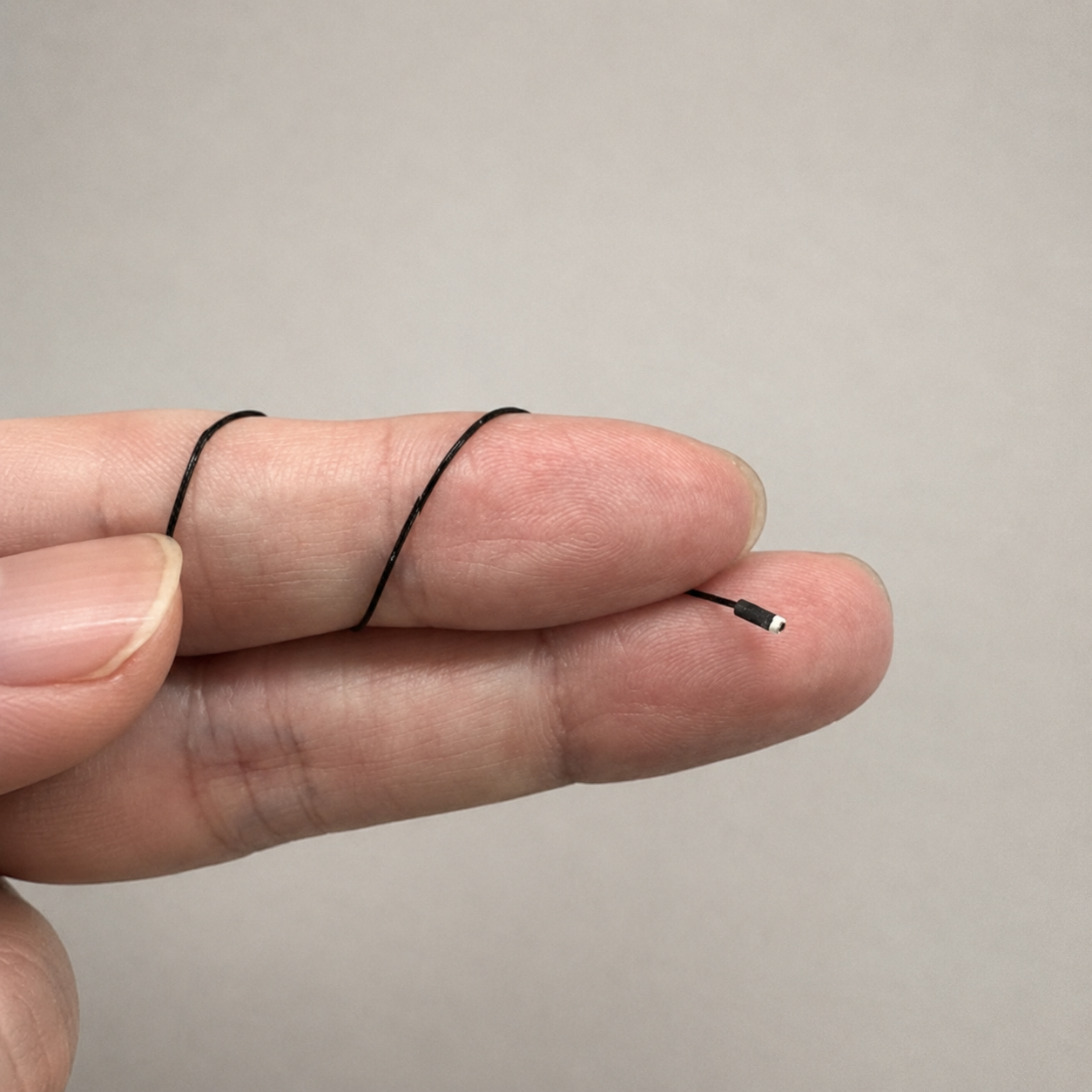 The tiny camera tip on a fingertip with its ultra-thin, flexible cable
